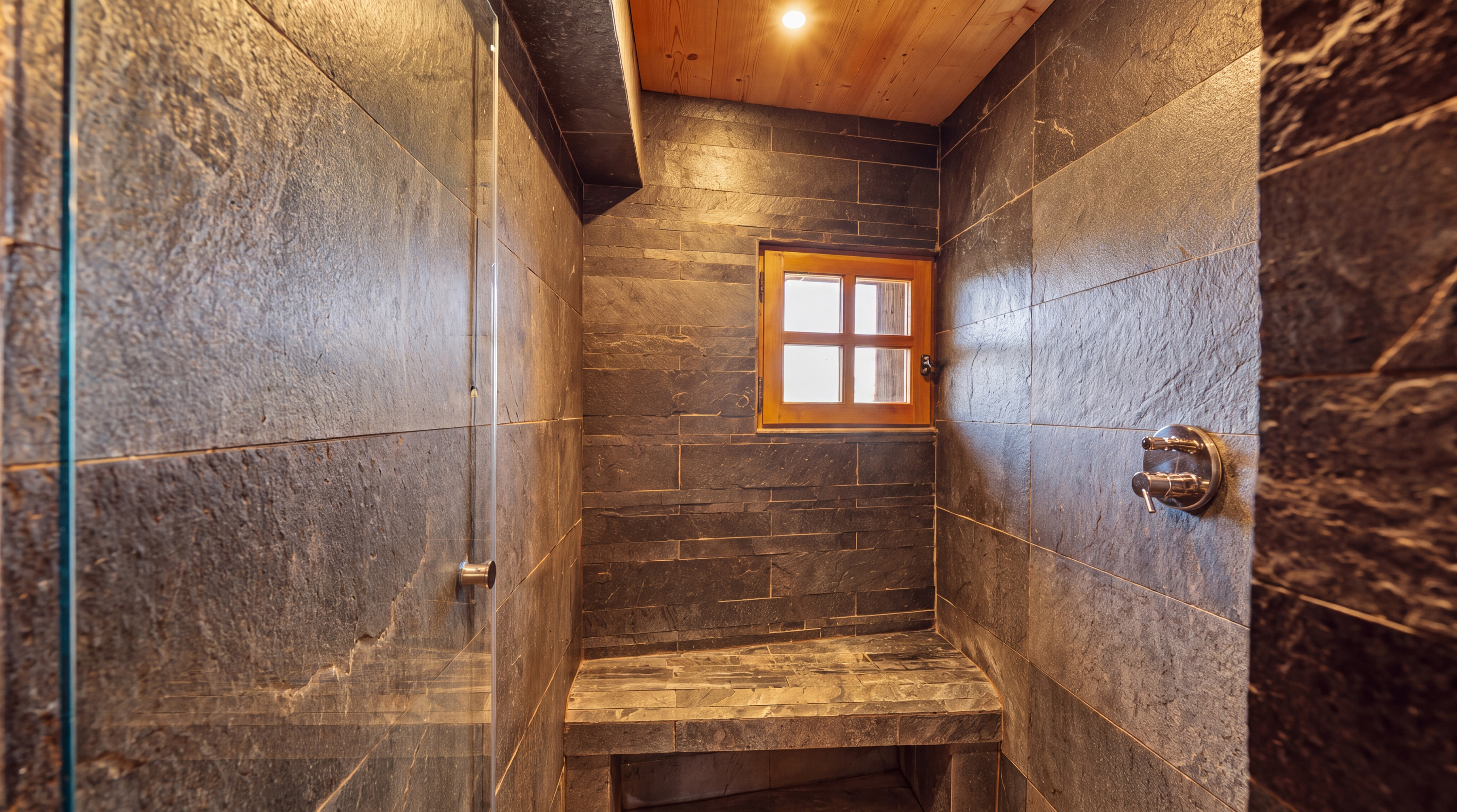 Walk-in shower with dark stone walls