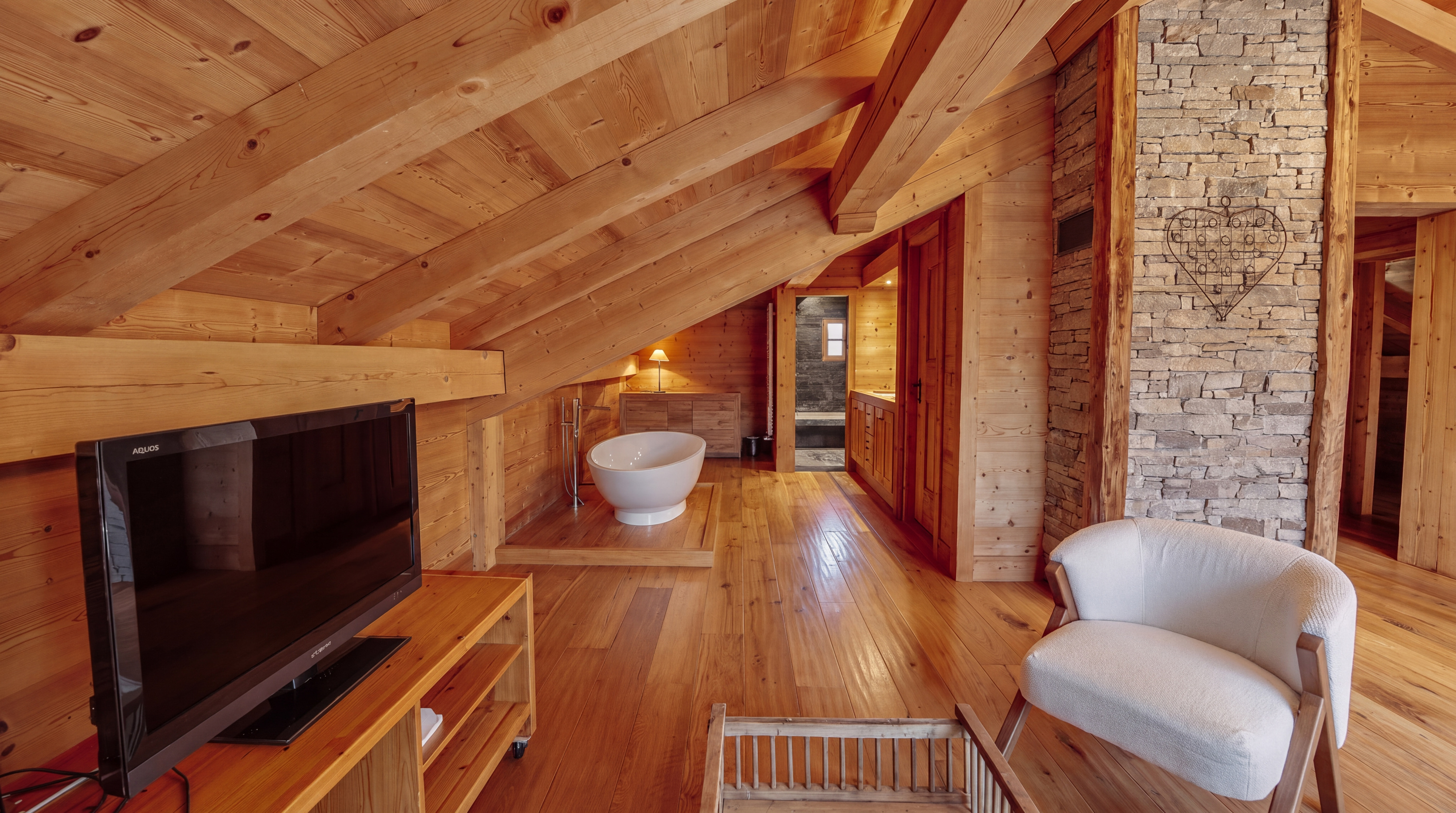 Principal suite lounge corner with television and bathtub